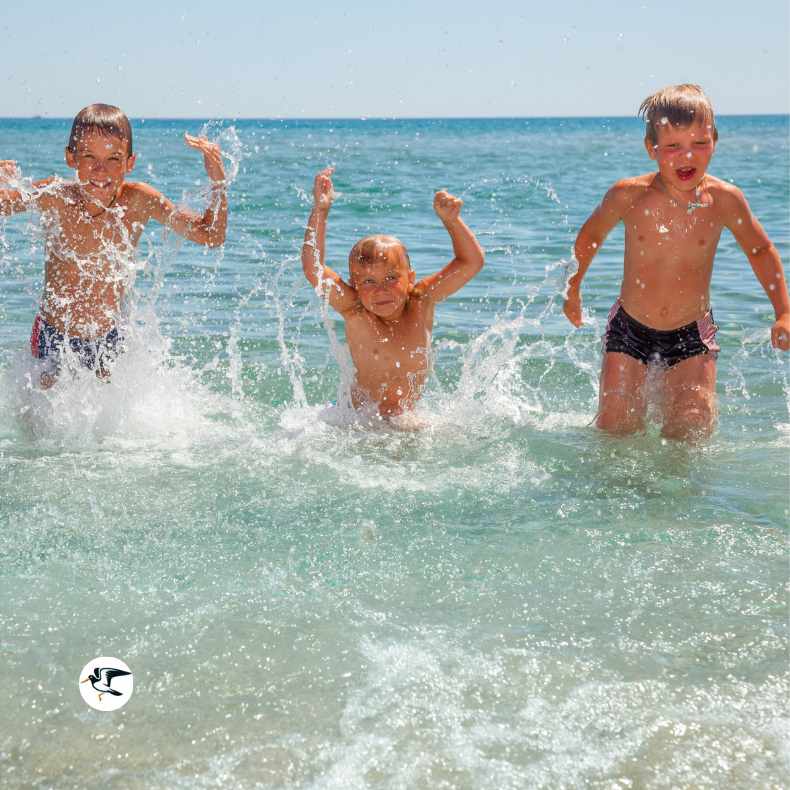 Children splashing in the sea in Devon