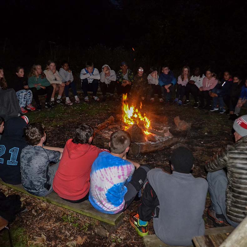 Children around a campfire at night